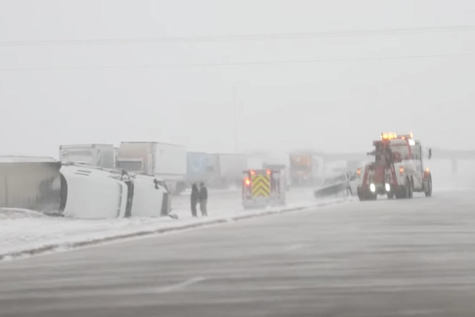 Emergency crews examine a flipped over freight truck on a snowy interstate. (Aaron Rigsby / LSM)