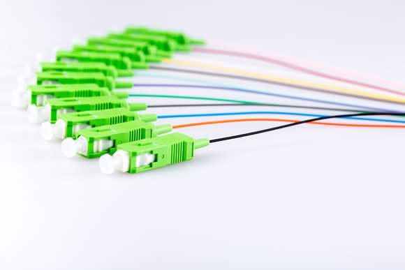 A bundle of fiber-optic network cables fanned out on a white table.