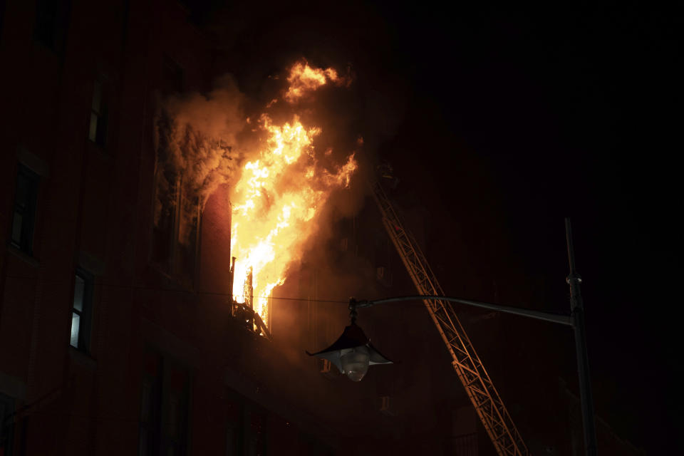 Fire blows out of a window in the Chinatown section of New York, Thursday, Jan. 23, 2020. New York City firefighters battled a raging blaze at a building in the city's Chinatown area Thursday night, Firefighters said they were called about 8:45 p.m. to 70 Mulberry Street for a fire on the fourth and fifth floors of the building, NYFD officials said. (AP Photo/Robert Bumsted)