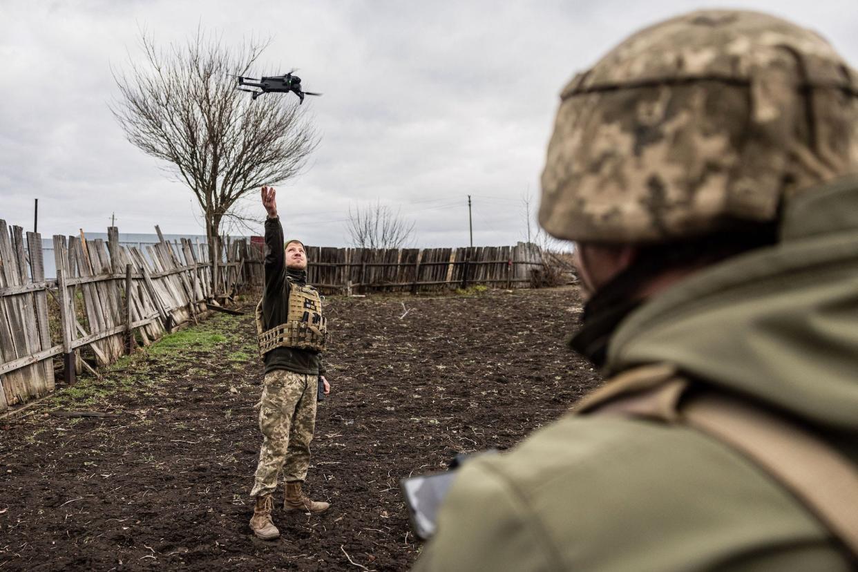 A Ukrainian soldier launching a drone