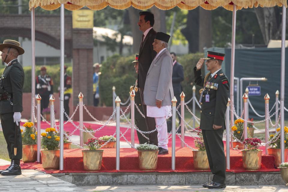 Qatar's Emir Sheikh Tamim bin Hamad Al Thani, center behind, stands with Nepal's President Ram Chandra Poudel, center front as he receives guard of honor at his arrival at the airport in Kathmandu, Nepal, Tuesday, April 23, 2024. The emir is on a two-days visit to the Himalayan nation. (AP Photo/Niranjan Shreshta)