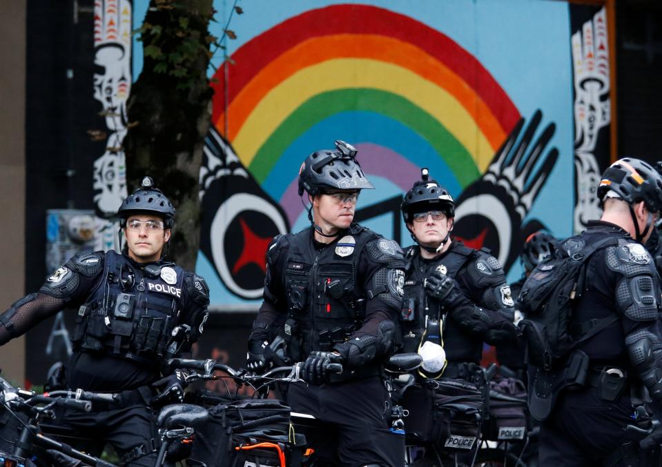 Officers on bicycles stand under a rainbow mural as Seattle Police retake the Capitol Hill Occupied Protest (CHOP) area, including their East Precinct, in Seattle, Washington (REUTERS)