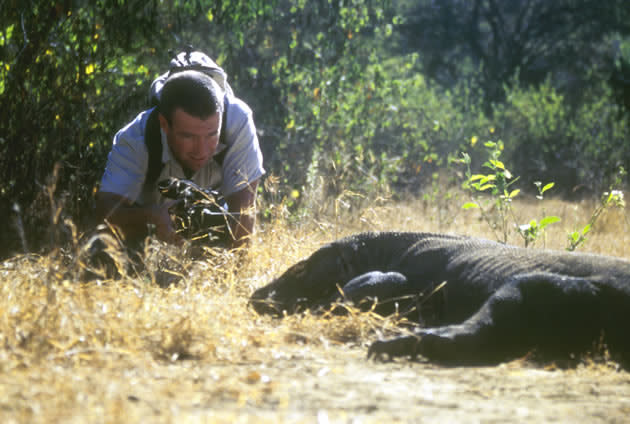 Hayden Turner crouches with his camera as he records the movements of a Komodo dragon in Indonesia. (Photo courtesy of NGCI/Thompson)