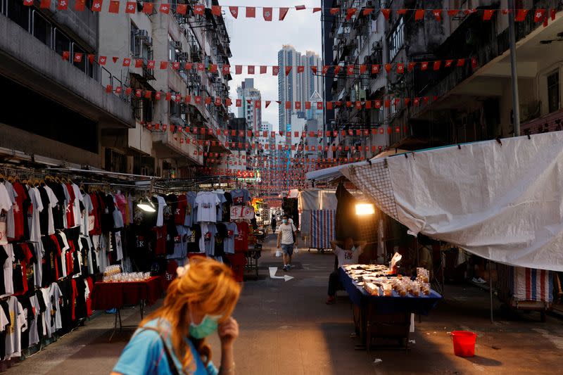 FILE PHOTO: People walk underneath rows of Chinese and Hong Kong flags hanging over Temple Street in Hong Kong