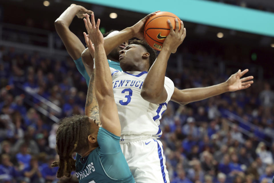 Kentucky's Adou Thiero (3) shoots between UNC Wilmington's Shykeim Phillips, bottom, and Khamari McGriff, top, during the first half of an NCAA college basketball game in Lexington, Ky., Saturday, Dec. 2, 2023. (AP Photo/James Crisp)