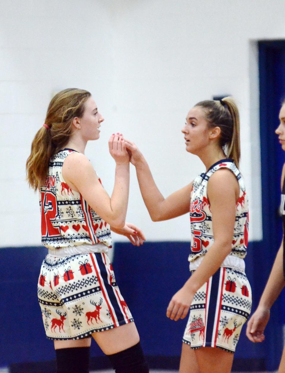 Mackinaw City players Larissa Huffman (left) and Marlie Postula celebrate the victory at the final buzzer Wednesday.