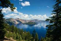 <p>The main attraction at <a href="https://www.nationalparks.org/explore-parks/crater-lake-national-park" rel="nofollow noopener" target="_blank" data-ylk="slk:Crater Lake;elm:context_link;itc:0;sec:content-canvas" class="link ">Crater Lake</a> is, well, the lake: it's the deepest one in the country and the seventh deepest lake in the world. It's inside a caldera (a volcanic basin) and was created when a large eruption caused 12,000 foot high Mount Mazama to collapse over 7,000 years ago. It's also one of the clearest lakes in the world and surrounded by lush evergreens, mountains, and wide open sky. </p>