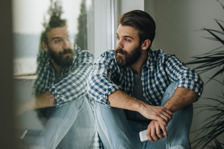 Person looking out their window and looking lonely