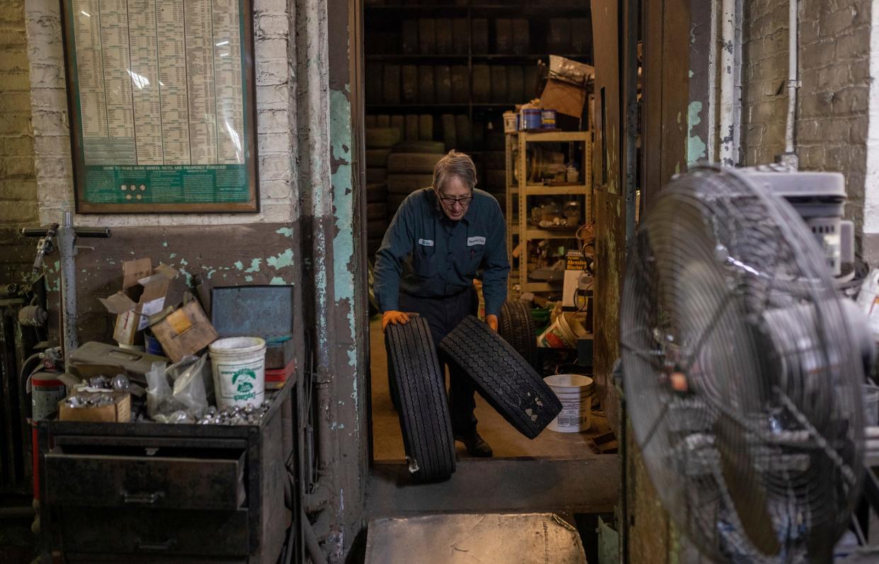 Mike Warholak Jr. rolls a tire on the garage floor during the last day of ownership by the Warholak family inside the Warholak Tire Service garage in Detroit on Tuesday, Oct. 31, 2023.