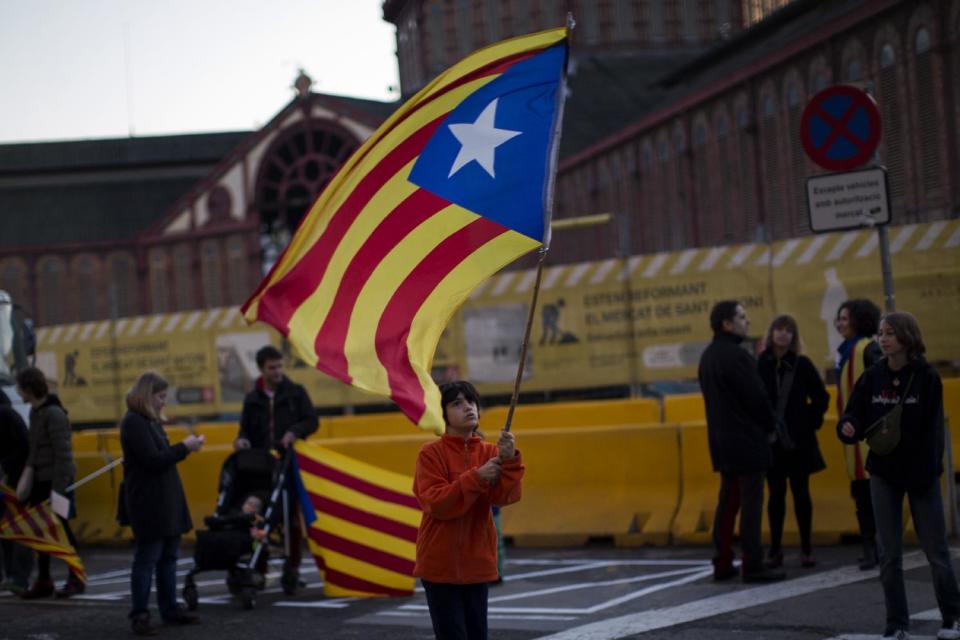 In this photo taken on Sunday, Jan. 12, 2014, a boy waves an "estelada" flag during a pro-independence event to celebrate the Catalan National Day that commemorates the takeover of Catalonia by Spanish troops in 1714, in Barcelona, Spain. After years of mass protests by Catalans demanding the right to decide whether they want to break away from Spain and form a new European nation, the wealthy northeastern region’s lawmakers vote to ask permission from Spanish authorities to hold a secession referendum in November. The request eight months ahead of a Scottish independence referendum is certain to be denied by the central government in Madrid but is virtually guaranteed of generating even more separatist fervor. (AP Photo/Emilio Morenatti)