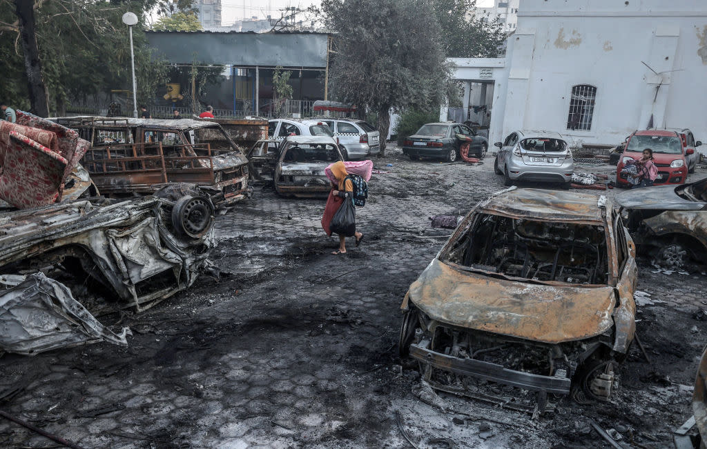  Boy tries to salvage useable items from wreckage of Gaza's Al-Ahli Baptist Hospital. 