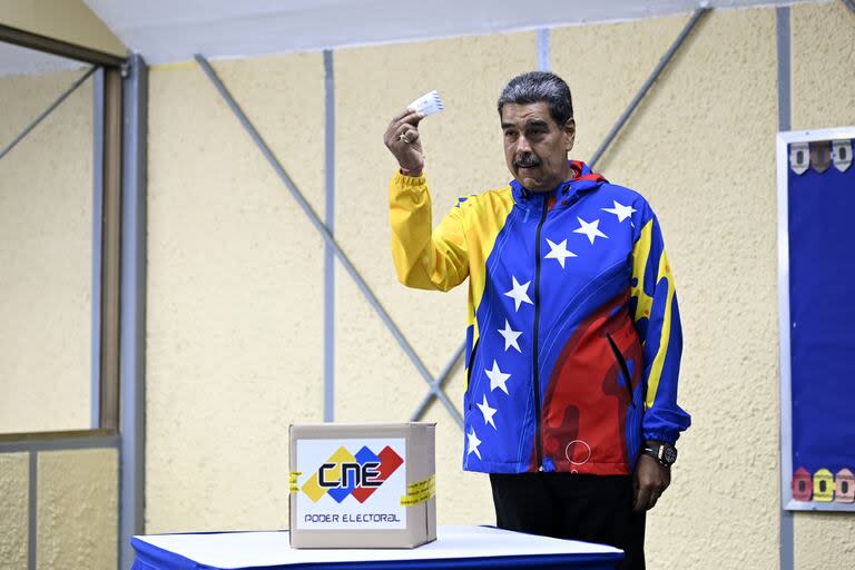 El presidente venezolano, Nicolás Maduro, muestra su voto previo a depositarlo en una urna durante las elecciones presidenciales, en Caracas, Venezuela, el 28 de julio de 2024. 