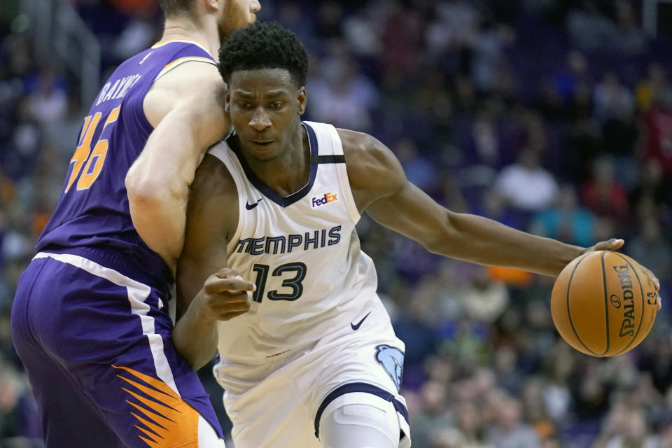 Memphis Grizzlies forward Jaren Jackson Jr. (13) drives against Phoenix Suns center Aron Baynes in the first half during an NBA basketball game, Sunday, Jan. 5, 2020, in Phoenix. (AP Photo/Rick Scuteri)