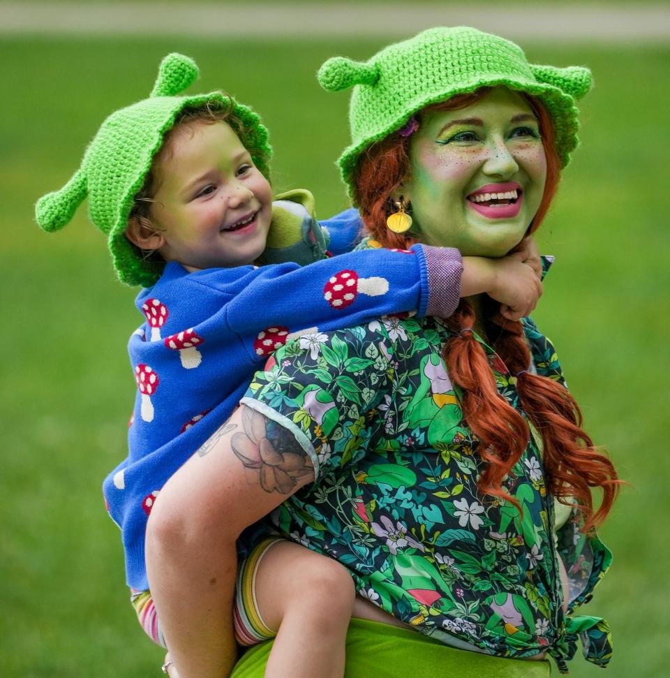 Mary Dumke and Vera, 4, share a moment as they listen to songs from the movie during Shrekfest Saturday, Sept. 3, 2022, located at Humboldt Park in Milwaukee. 'We love the soundtrack and we love a good fart joke,' Dumke said.