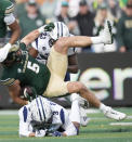 Colorado State tight end Dallin Holker, center, is upended after catching a pass by Nevada cornerback Michael Coats Jr., bottom, as defensive back Richard Toney Jr. comes in to join in the stop in the first half of an NCAA college football game Saturday, Nov. 18, 2023, in Fort Collins, Colo. (AP Photo/David Zalubowski)