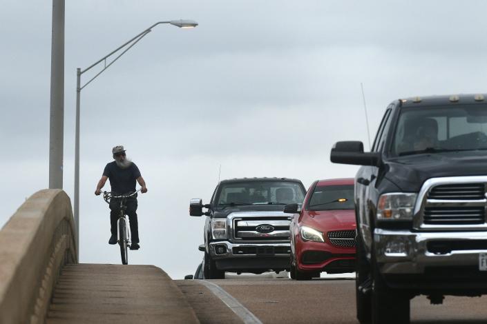 A bicyclist uses the elevated sidewalk to cross Brooks Bridge in Fort Walton Beach on Friday morning. There were about 33 fatal pedestrian/bicycle and motorcycles crashes last year in Okaloosa and Walton counties.