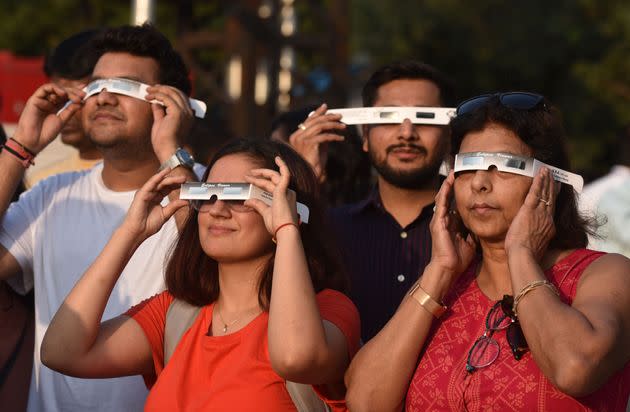People watch the partial solar eclipse through protective glasses in New Delhi, India. (Photo: Sonu Mehta/Hindustan Times via Getty Images)