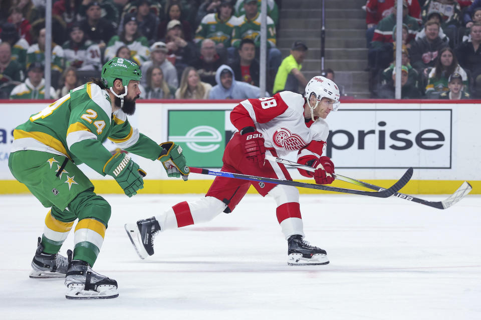 Detroit Red Wings right wing Patrick Kane (88) shoots while Minnesota Wild defenseman Zach Bogosian (24) defends during the first period of an NHL hockey game Wednesday, Dec. 27, 2023, in St. Paul, Minn. (AP Photo/Matt Krohn)