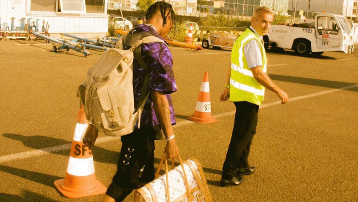 Singer Travis Scott is seen walking with a Louis Vuitton Handbag