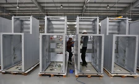 Employees prepare high voltage transmission switch panels inside the plant of Schneider Electric Infrastructure Ltd. on the outskirts of Vadodara in Gujarat, India, November 5, 2015. REUTERS/Amit Dave