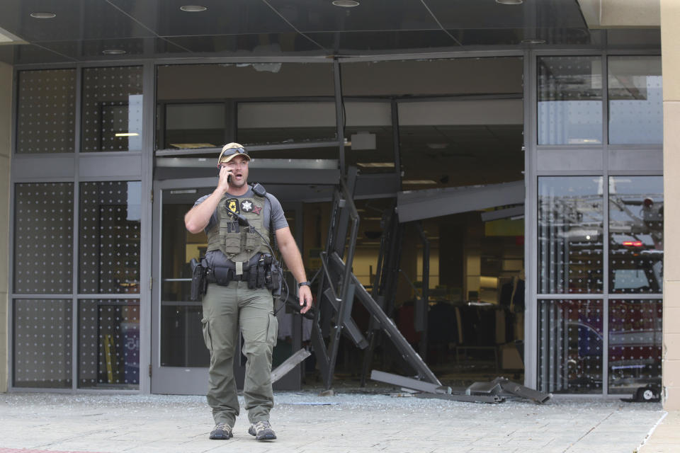 A state police officer stands outside of a Woodfield Mall entrance after a man drove an SUV into a Sears store in the Chicago suburb of Schaumburg, Ill., on Friday, Sept. 20, 2019. (John J. Kim/Chicago Tribune via AP)