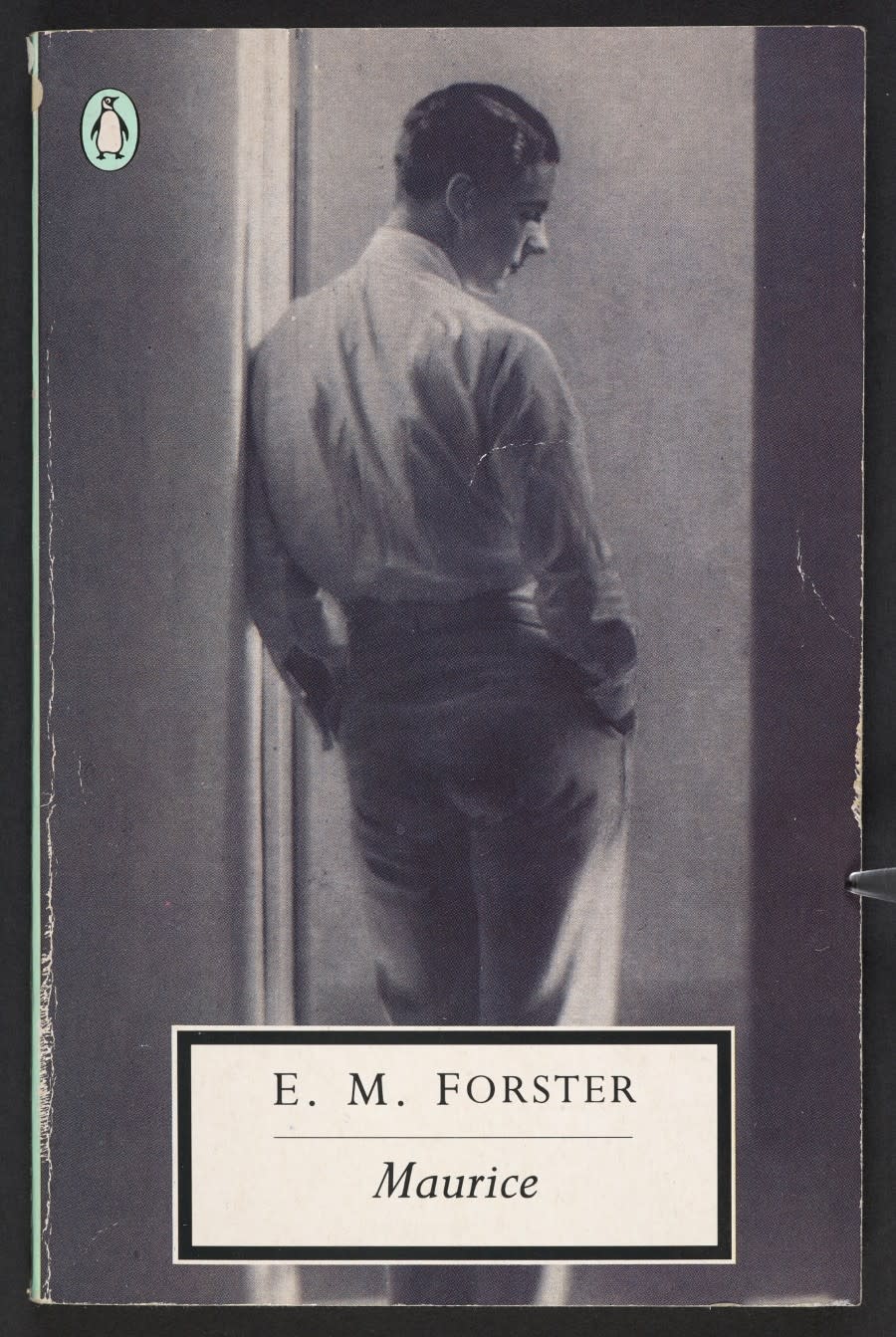 The cover of E.M. Forster's Maurice featuring a black and white photo of a man in a door frame with his back to the camera.