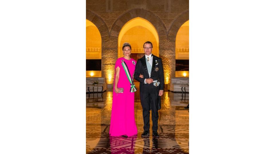 Crown Princess Victoria in a pink caped dress with her husband