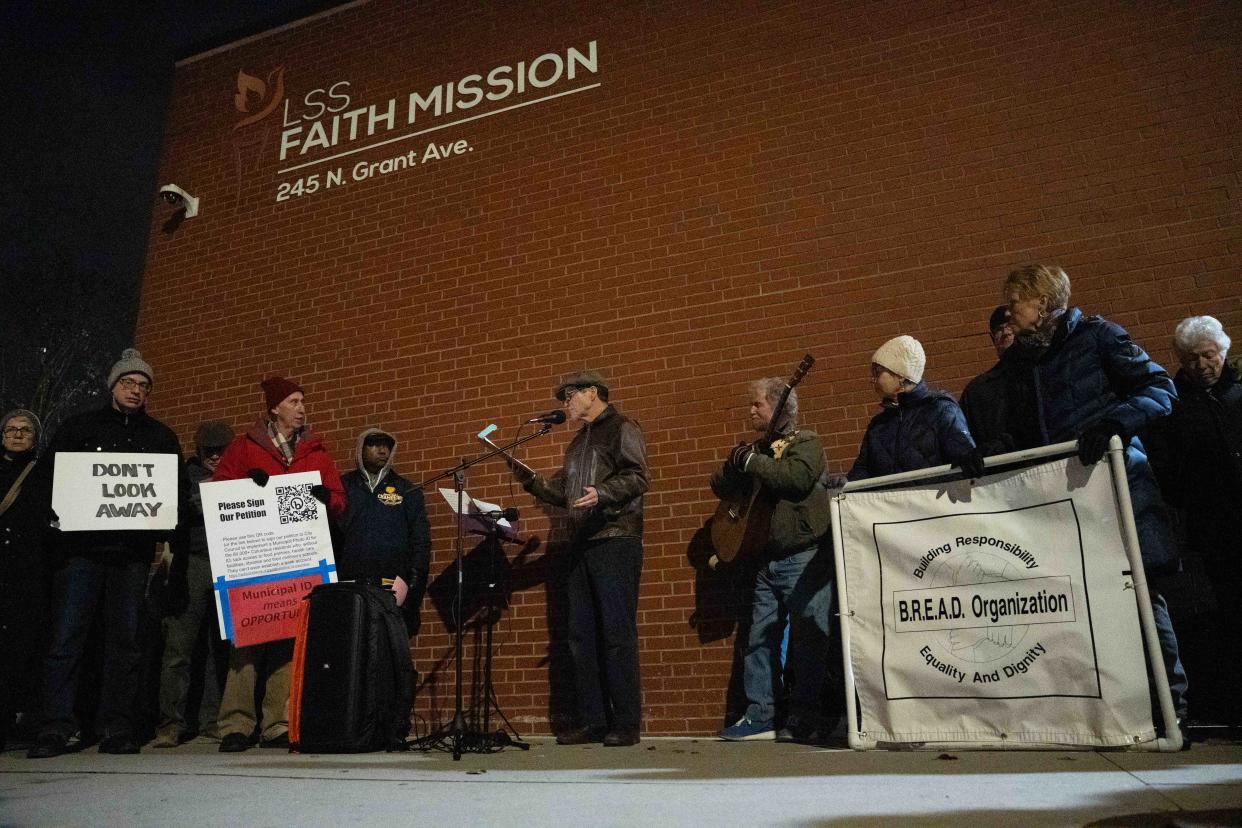 Edd Hoffman, a member of both B.R.E.A.D. and One ID Columbus, speaks about the need for Columbus and Franklin County to better address homelessness on Wednesday evening at Faith Mission before introducing local folk singer Bill Cohen.
