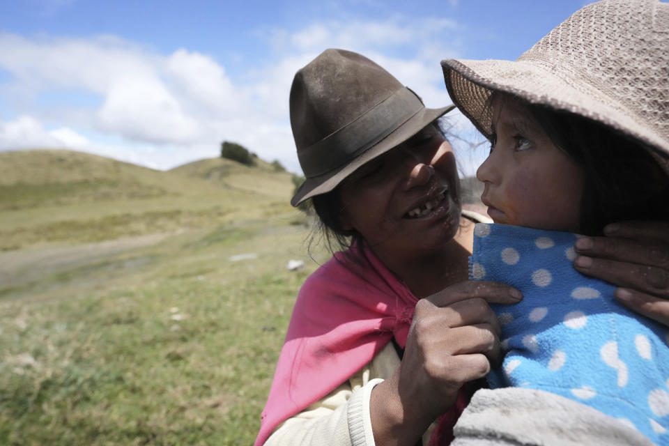 Una mujer indígena calma a su hija antes de que reciba la vacuna para la gripe en Cotopaxi, Ecuador, el viernes 2 de diciembre de 2022. La desnutrición infantil es crónica entre los 18 millones de habitantes de Ecuador, golpeando más a las zonas rurales y a la población indígena del país, de acuerdo con Erwin Ronquillo, secretario del programa gubernamental Ecuador Crece Sin Desnutrición. (AP Foto/Dolores Ochoa)