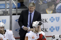 Calgary Flames head coach Bill Peters stands behind Andrew Mangiapane (88) during the third period of an NHL hockey game against the Pittsburgh Penguins in Pittsburgh, Monday, Nov. 25, 2019. The Penguins won in overtime 3-2. (AP Photo/Gene J. Puskar)