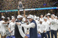 Akron athletic director Charles Guthrie and head coach John Groce celebrate their victory over Kent State at the end of an NCAA college basketball game in the championship of the Mid-American Conference tournament, Saturday, March 16, 2024, in Cleveland. (AP Photo/Phil Long)