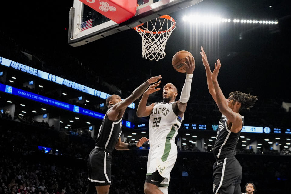 Milwaukee Bucks forward Khris Middleton (22) shoots against Brooklyn Nets forward Dariq Whitehead, left, and forward Noah Clowney during the first half of an NBA basketball game in New York, Wednesday, Dec. 27, 2023. (AP Photo/Peter K. Afriyie)