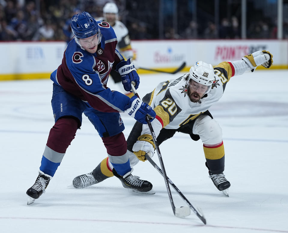 Colorado Avalanche defenseman Cale Makar (8) and Vegas Golden Knights center Chandler Stephenson (20) reach for the puck during the third period in Game 2 of an NHL hockey Stanley Cup second-round playoff series Wednesday, June 2, 2021, in Denver. (AP Photo/Jack Dempsey)