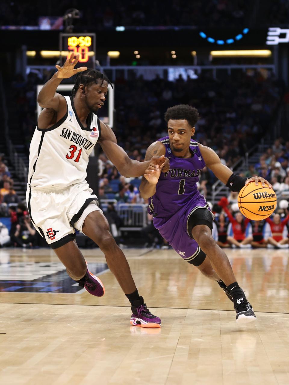 Mar 18, 2023; Orlando, FL, USA; Furman Paladins guard JP Pegues (1) drives against San Diego State Aztecs forward Nathan Mensah (31) during the second half in the second round of the 2023 NCAA Tournament at Legacy Arena. Mandatory Credit: Matt Pendleton-USA TODAY Sports