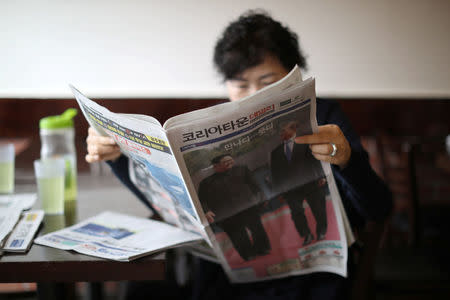A woman reads a newspaper with a front page story about the inter-Korean summit between North Korea’s Kim Jong Un and South Korean President Moon Jae-in, in Koreatown, Los Angeles, California, April 27, 2018. REUTERS/Lucy Nicholson