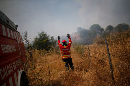 Firefighters help to put out a fire in Pinheiro e Garrado, near Silves, Portugal August 8, 2018. REUTERS/Pedro Nunes