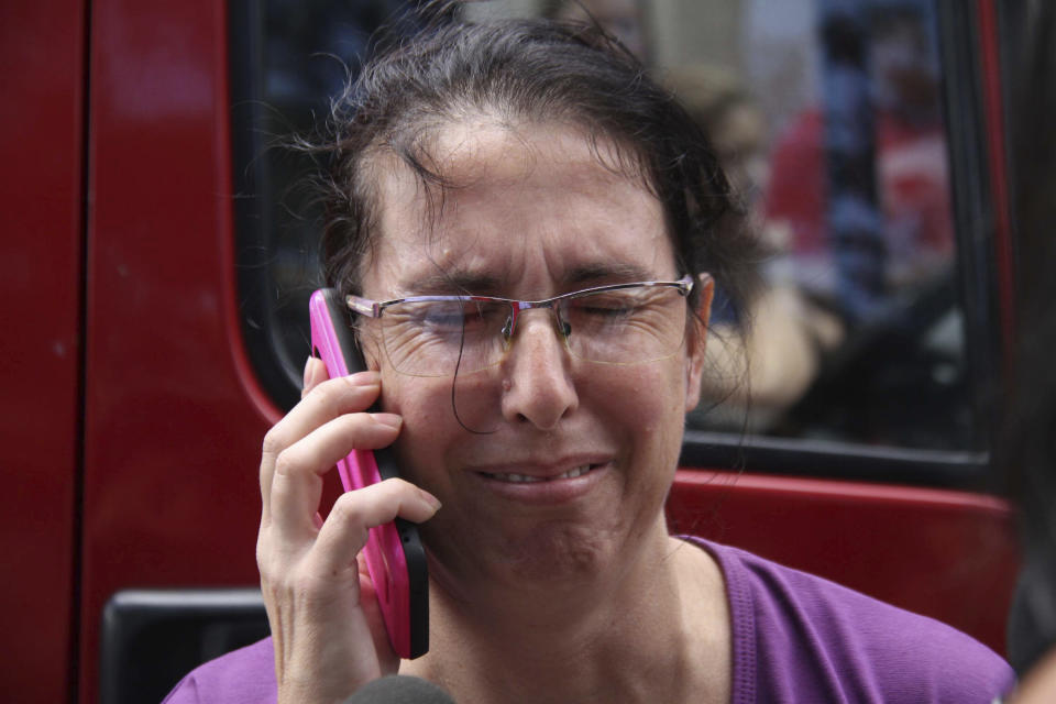 Una mujer usa su celular mientras espera por noticias afuera de la escuela pública Raul Brasil en Suzano, Brasil, el miércoles, 13 de marzo del 2019. (Mauricio Sumiya/Futura Press vía AP)