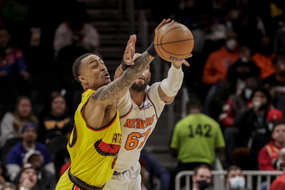 Atlanta Hawks forward John Collins (20) deflects a pass intended for New York Knicks center Taj Gibson (67) during the first half of an NBA basketball game Saturday, Jan. 15, 2022, in Atlanta. (AP Photo/Butch Dill)