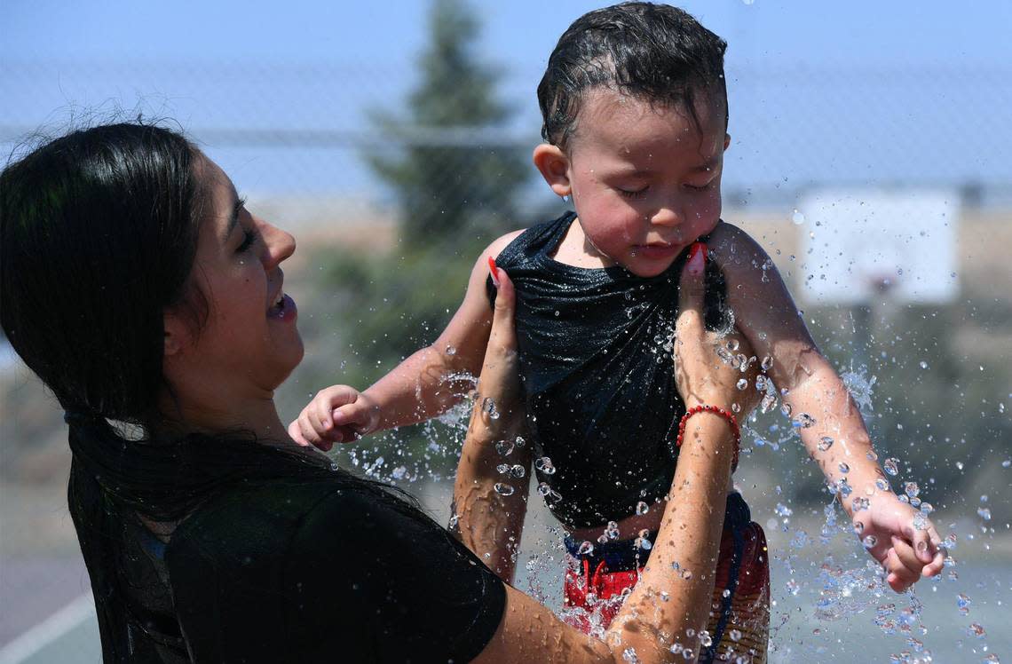 Zaire Prince, 1, is held by his mother Bailee Liggett as they both cool down at Martin Ray Reilly Park’s splash park on a hot Wednesday afternoon, Sept. 7, 2022 in Fresno.