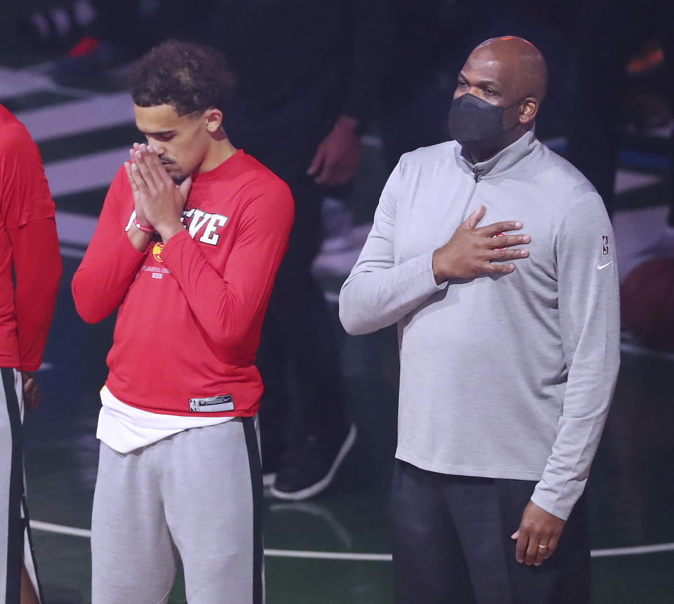 Atlanta Hawks guard Trae Young and interim head coach Nate McMillan during the National Anthem to begin game 1 against theMilwaukee Bucks in the NBA Eastern Conference Finals at Fiserv Forum on Wednesday, June 23, 2021, in Milwaukee. (Curtis Compton/Atlanta Journal-Constitution via AP)