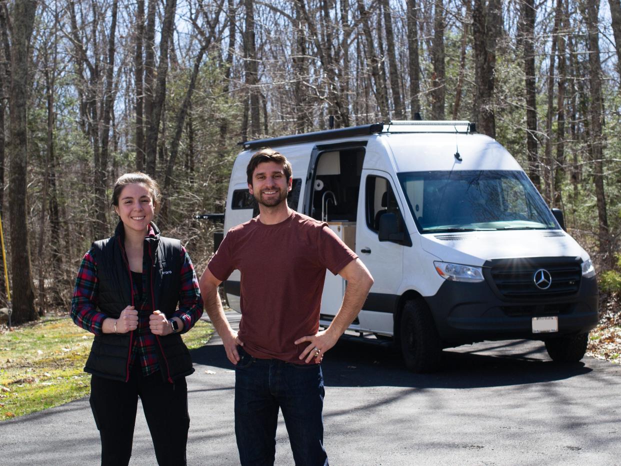 Austin and Melanie Shoecraft standing in front of their van with trees in the background