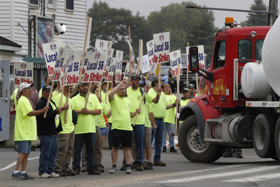 Striking shipbuilders pause their march to allow a truck to enter Bath Iron Works, Monday, June 22, 2020, in Bath, Maine. Production workers rejected the company's three-year contract offer Sunday, threatening to further delay delivery of ships. (AP Photo/Robert F. Bukaty)