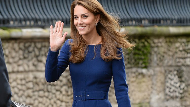 kate middleton in a blue dress with a sapphire ring, black clutch, and black heels