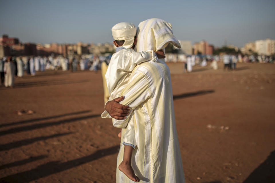 <p>A father holds his son as they attend Eid al-Adha prayers in Sale, north of Rabat, Morocco, Friday, Sept. 1, 2017. (Photo: Mosa’ab Elshamy/AP) </p>