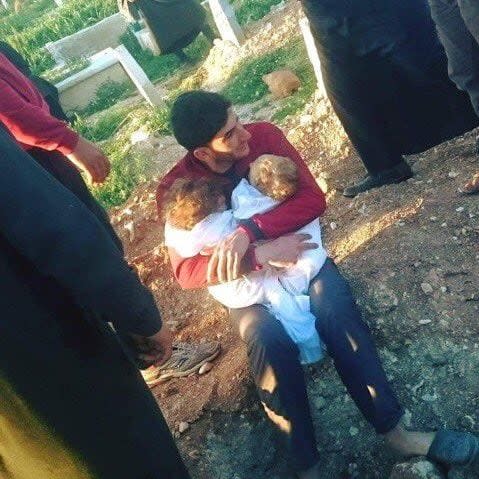 Abdulhadim al-Youssef hugs the shrouded bodies of his dead twin infants - Alaa al-Youssef/Alaa al-Youssef