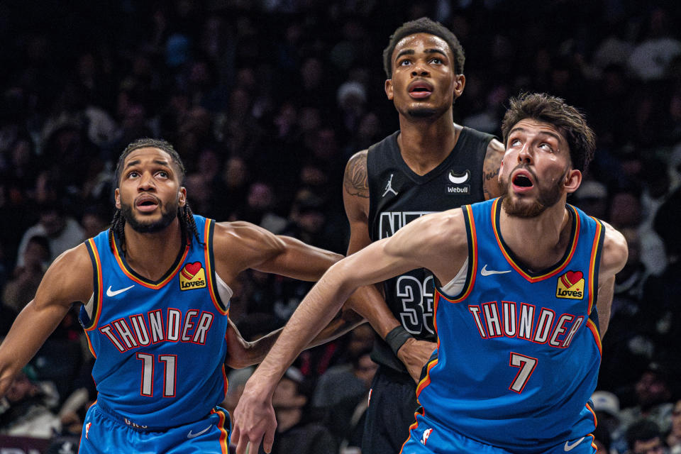 Oklahoma City Thunder forward Chet Holmgren (7) and guard Isaiah Joe (11) and Brooklyn Nets center Nic Claxton (33) wait for a rebound during the second half of an NBA basketball game in New York, Friday, Jan. 5, 2024. (AP Photo/Peter K. Afriyie)