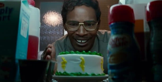 Max Dillon looking down on a green and yellow cake in his fridge in "The Amazing Spider-Man 2"