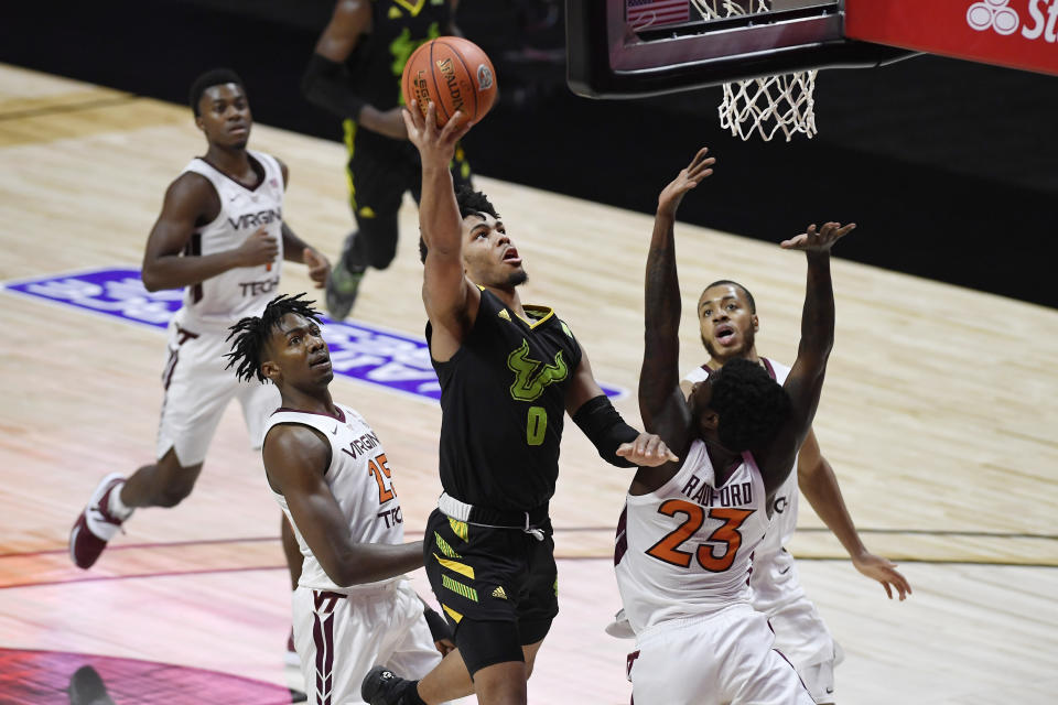 South Florida's David Collins goes to the basket as Virginia Tech's Jalen Cone, left, and Virginia Tech's Tyrece Radford, right, defend in the first half of an NCAA college basketball game, Sunday, Nov. 29, 2020, in Uncasville, Conn. (AP Photo/Jessica Hill)