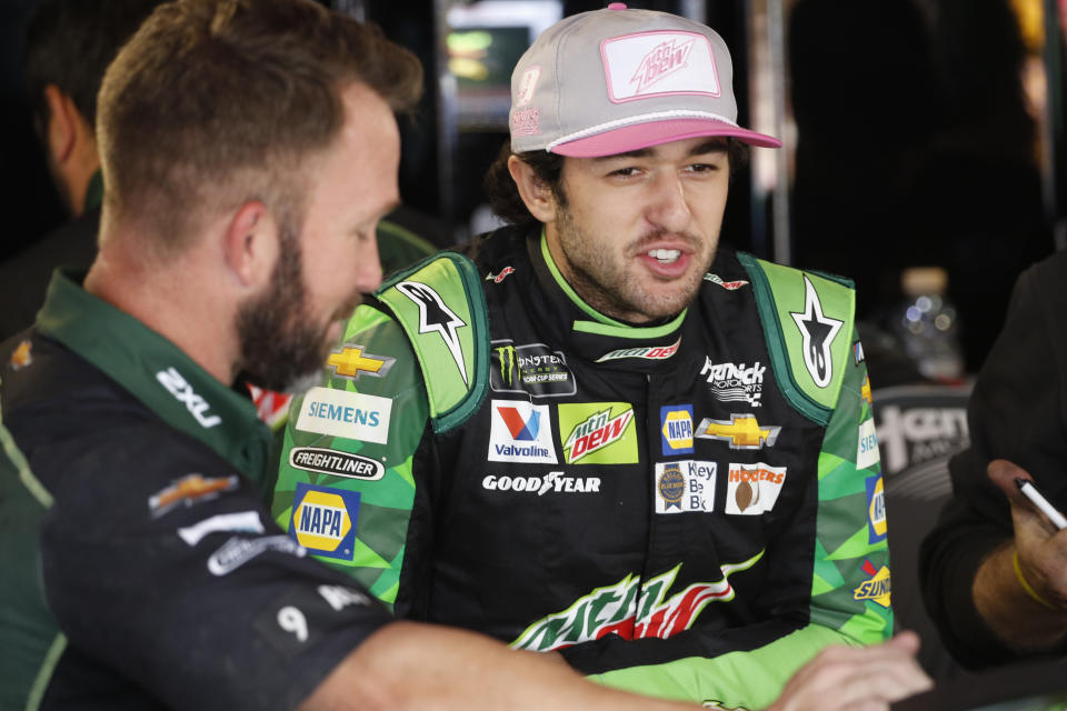 Chase Elliott talks with a crew member in the garage at Martinsville Speedway In Martinsville, Va., Saturday, Oct. 26, 2019. Elliott had an engine failure less than five minutes into the opening practice for the third round of NASCAR's playoffs. (AP Photo/Steve Helber)