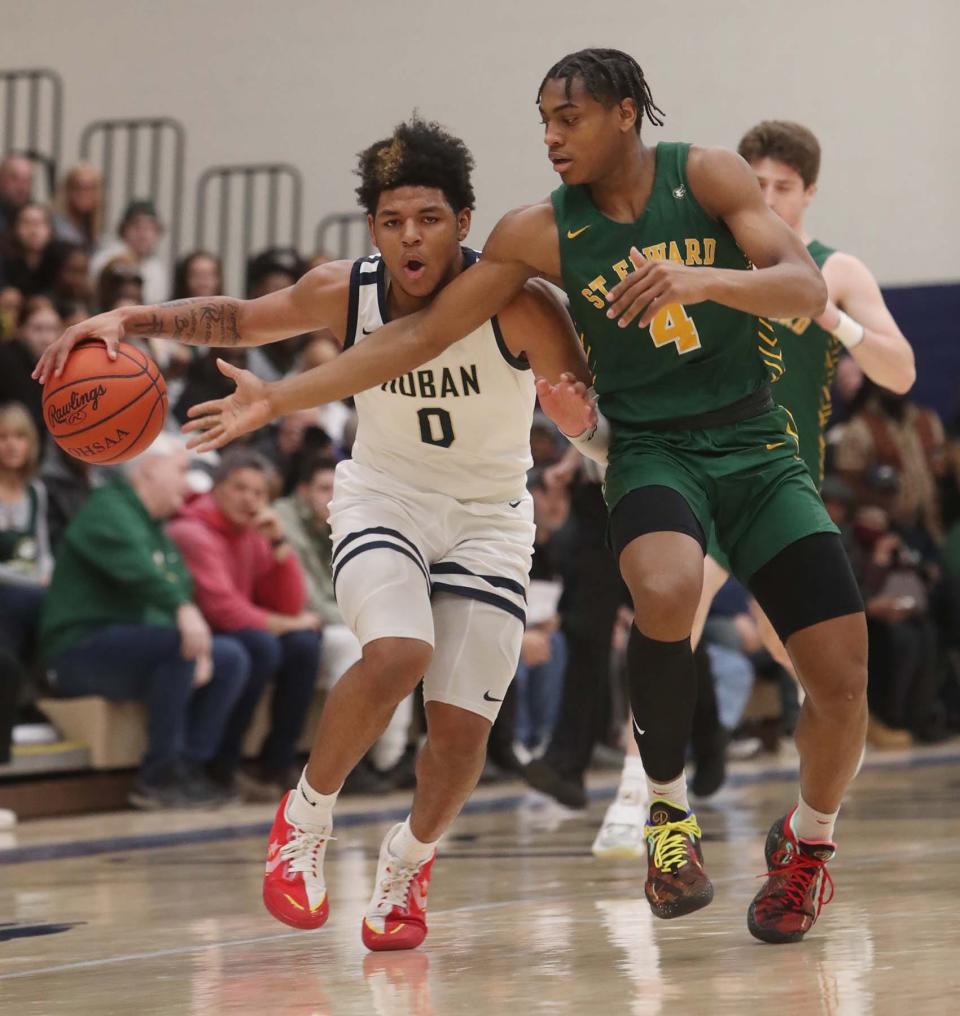 Jonas Nichols, left, of Hoban takes the ball down court under pressure from Jair Knight of St. Edward during the first period of their Division I Regional final game at Copley High School Saturday in Copley.